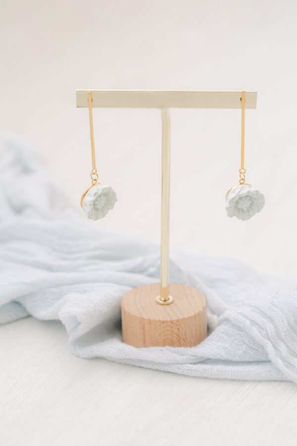 Brinco singular longo dourado de aço inox com uma flor